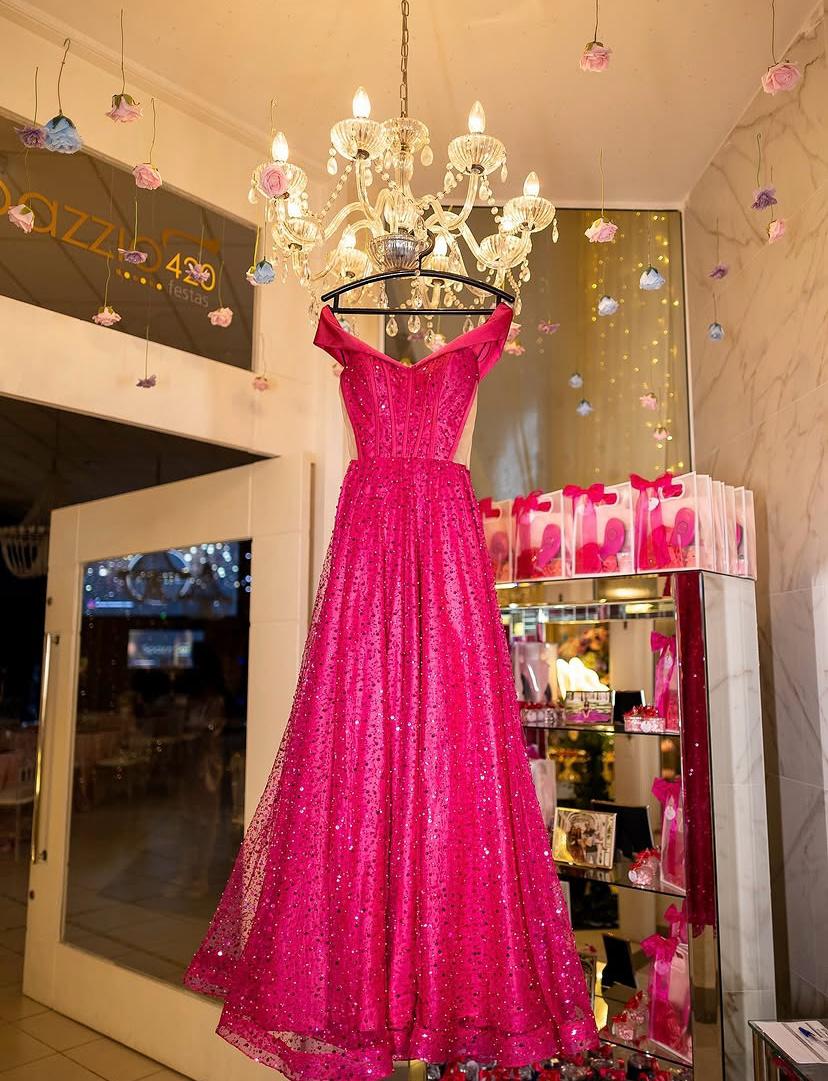Vestido pink pendurado sob lustre de cristal na entrada do salão